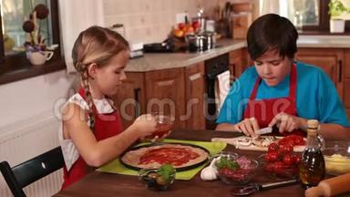 孩子们在家做披萨，传播和品尝酱汁